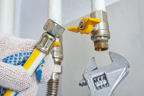 Gas line fitting with an adjustable wrench